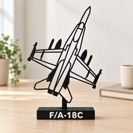 Digital lifestyle preview on an oak desk of the updated F/A-18C decorative silhouette model, with reinforced open detail lines, matte black finish and labelled display base.