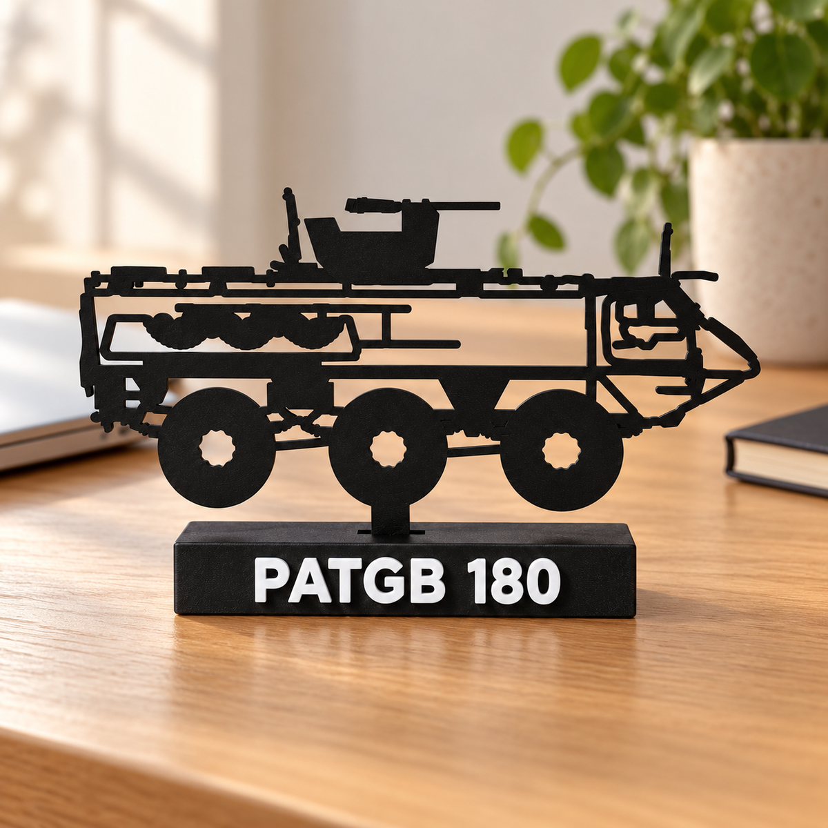 Lifestyle preview of the Swedish PATGB 180 silhouette display model on a wooden home-office desk, with its labelled black display base.