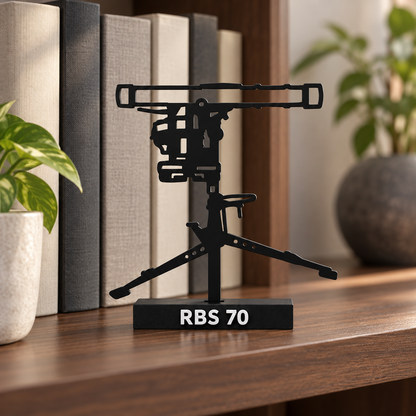 Lifestyle preview of the RBS 70 display model on a collector's bookshelf, with its labelled black base and recessed mounting slot.