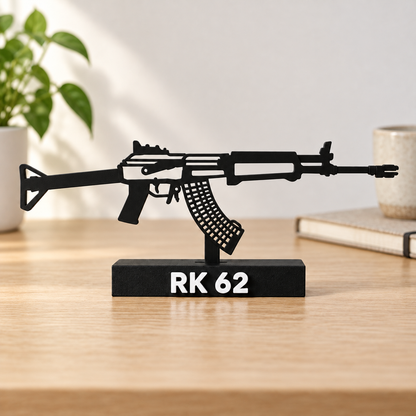 Digital lifestyle preview on an oak desk of the updated RK 62 decorative silhouette model, with reinforced open detail lines, matte black finish and labelled display base.